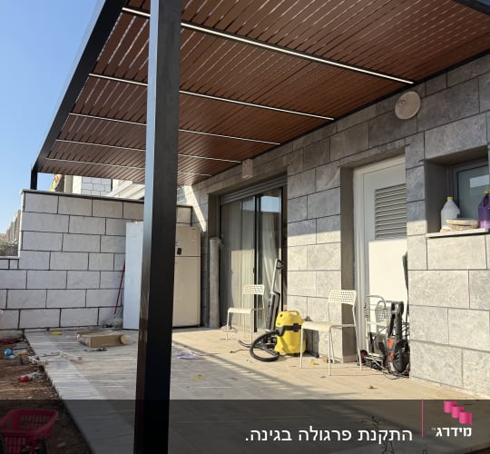פרגולת אלומיניום שחורה עם שלבי דמוי עץ ותאורת לדים מובנית במרפסת